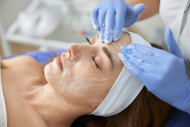 Profissional aplicando peeling químico no rosto de uma paciente na Clínica Essencial Estética