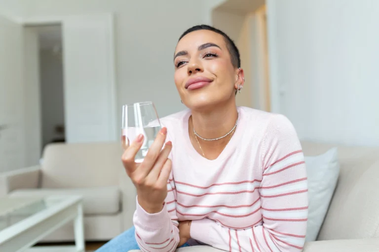 Paciente bebendo água após o tratamento de Lipo Enzimática na Clínica Essencial Estética, seguindo os cuidados pós-tratamento.