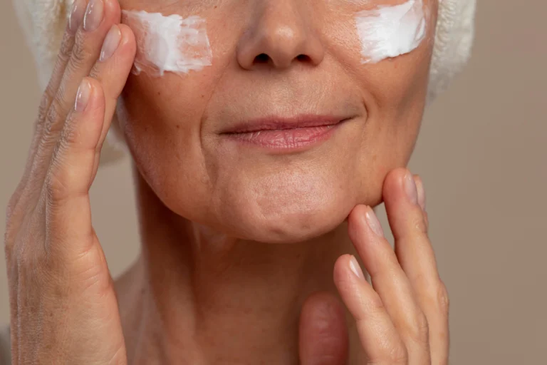 Paciente aplicando protetor solar no rosto após o tratamento Anti-Melasma Avançado na Clínica Essencial Estética