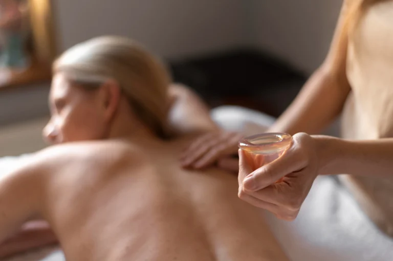 Profissional aplicando óleos calmantes em paciente durante a massagem relaxante na Clínica Essencial Estética